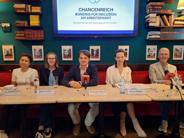 Die Teilnehmer*innen an der Pressekonferenz sitzen an einem Tisch