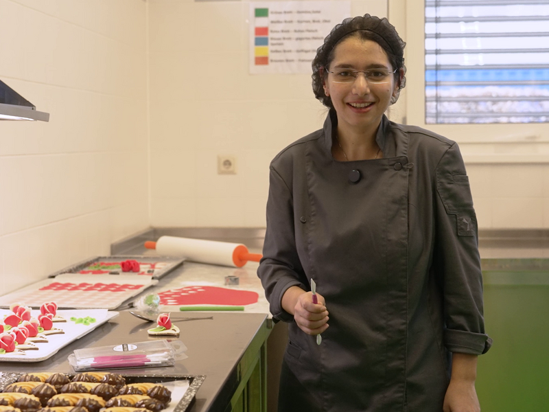 Eine junge Frau dekoriert Gebäck