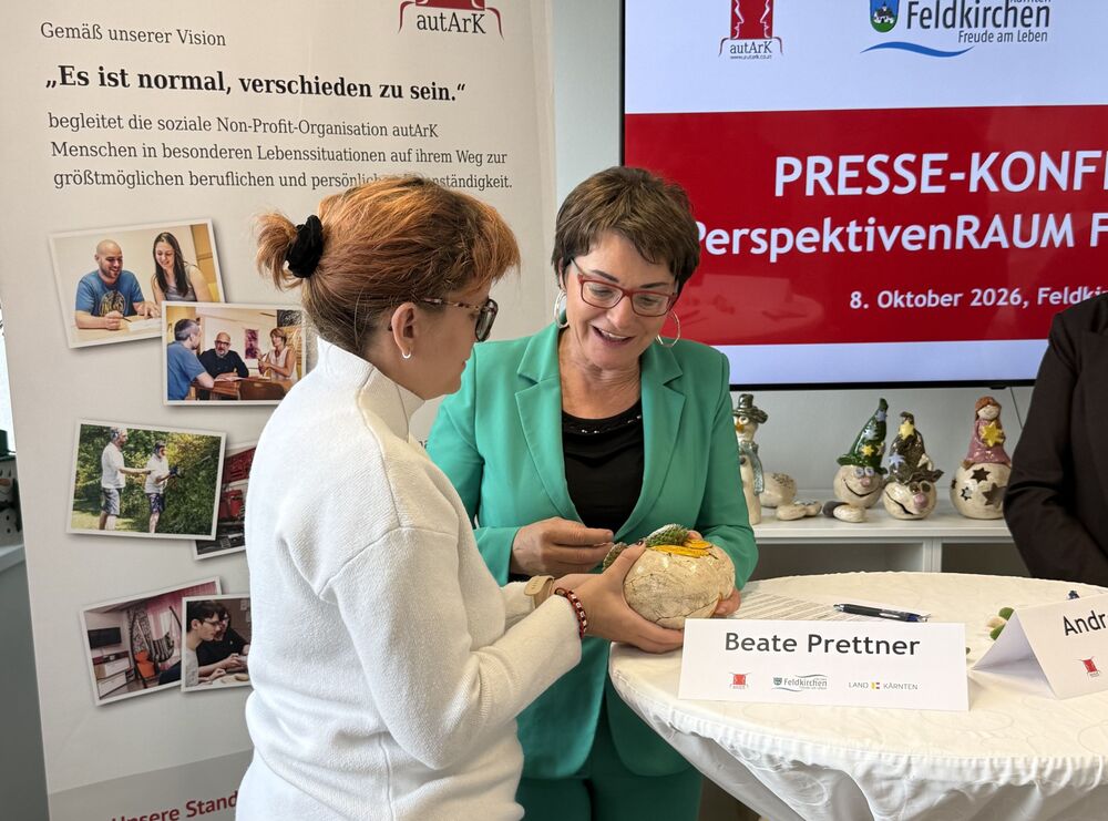 Beate Prettner erhält ein Geschenk und lächelt