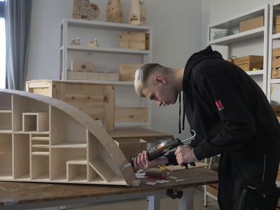 Eine Arbeitskraft leimt Holz