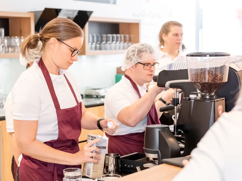 Mitarbeiter*innen bei der Kaffeezubereitung